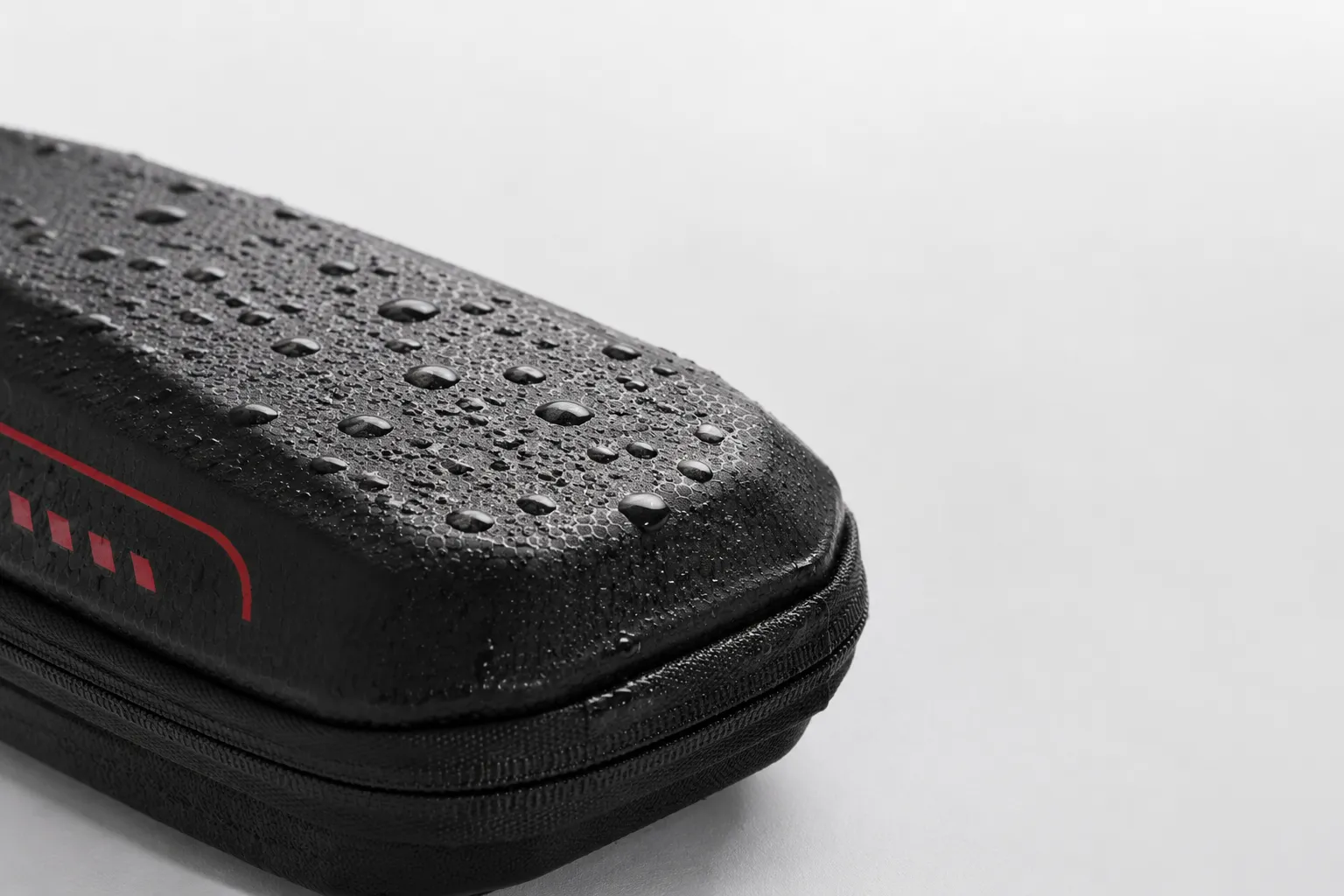 Water droplets beading on the black ZWHEEL scooter bag shell